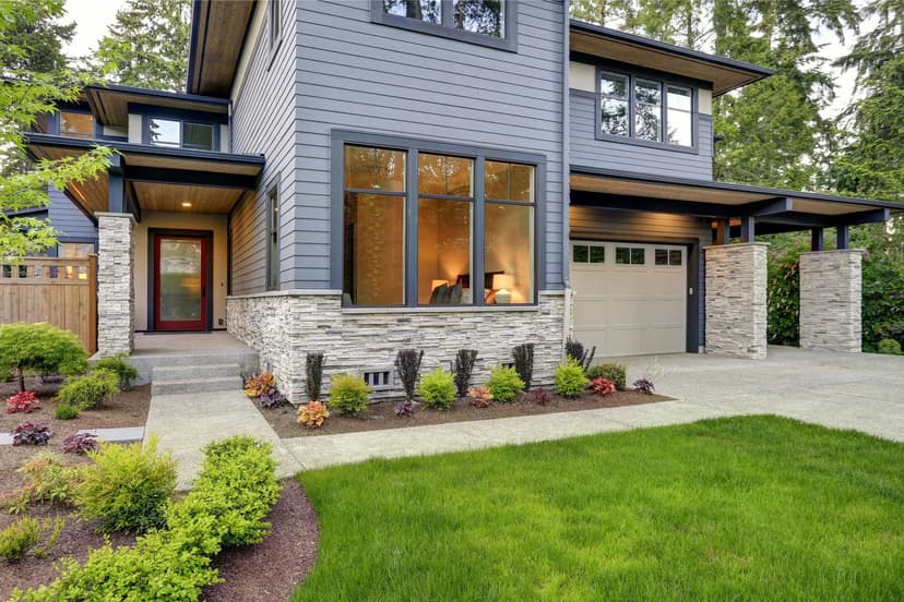 Modern two-story home with stone accents, landscaped yard, and garage in a serene setting.